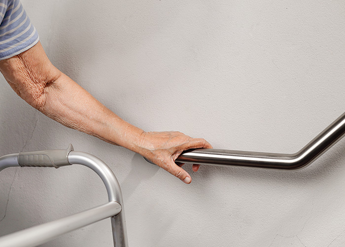 Image of elderly person holding onto grab bar